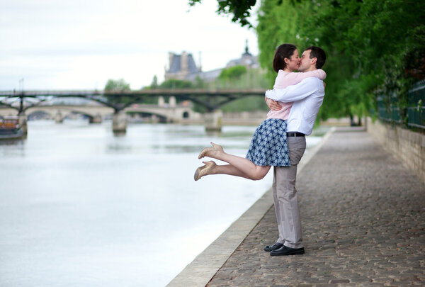 幸福浪漫情侣拥抱附近塞纳河，女孩跳跃 图片素材