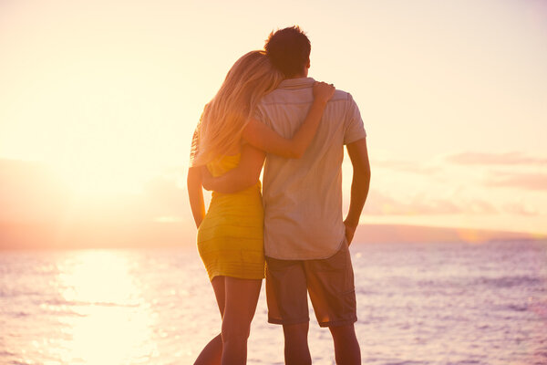 浪漫的情侣，在热带的海滩上看日落 图片素材