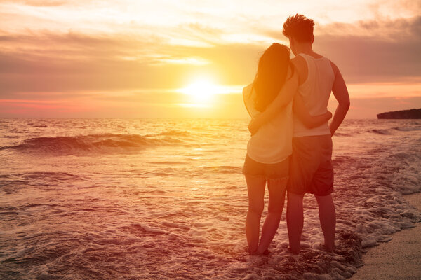 Young couple watching sunset on the beach 图片素材