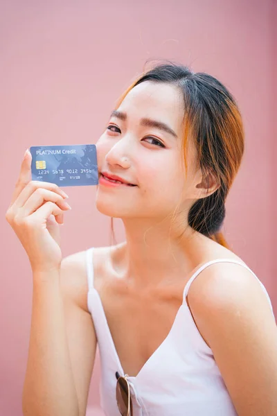 持有信用卡的美丽年轻亚洲女人的肖像.  图片素材