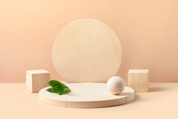木制自然形状产品的立柱。方块、球和板作为米色背景的讲台. 图片素材