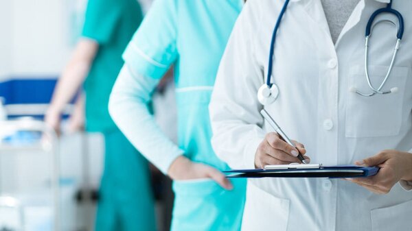 在医院工作的医务人员: 医生和护士检查病人的病历记录在剪贴板上, 医疗保健和医学考试的概念 图片素材