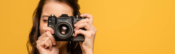 用黄色隔离的数码相机拍摄年轻女子全景照片 图片素材