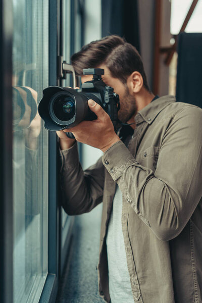 摄影师用相机在窗口 图片素材