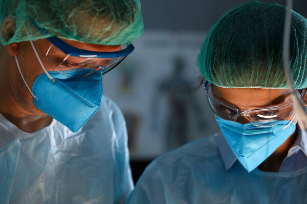 Surgeon and anastasiologist in uniform look down 图片素材