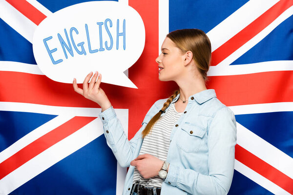 英国国旗背景上印有英文字母的带辫子的笑容可亲的漂亮姑娘拿着话筒 图片素材