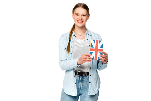 一个笑容可亲的漂亮姑娘，带着辫子，手里拿着一本书，上面挂着英国国旗，白色孤立着 图片素材
