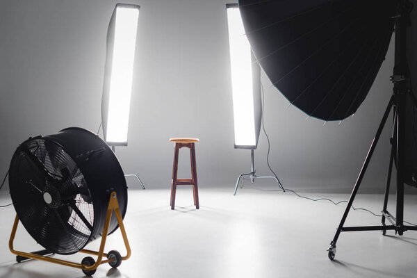 摄影演播室的数码相机、风扇、反射镜、木制凳子和灯光 图片素材