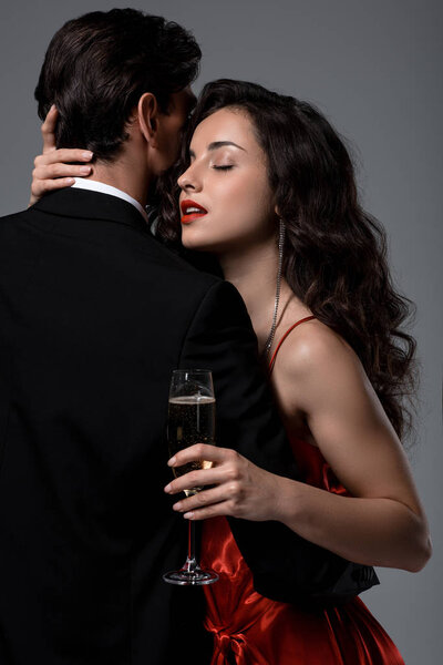 性感夫妻抱着香槟酒杯，与灰色隔离 图片素材