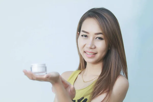 美丽的女人亚洲使用的皮肤护理产品、 保湿或 图片素材