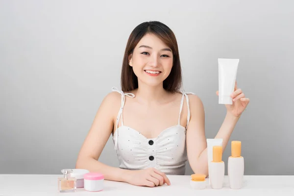 健康与美的概念-迷人的亚洲女人在皮肤上涂上乳霜，与白色背景隔离. 图片素材