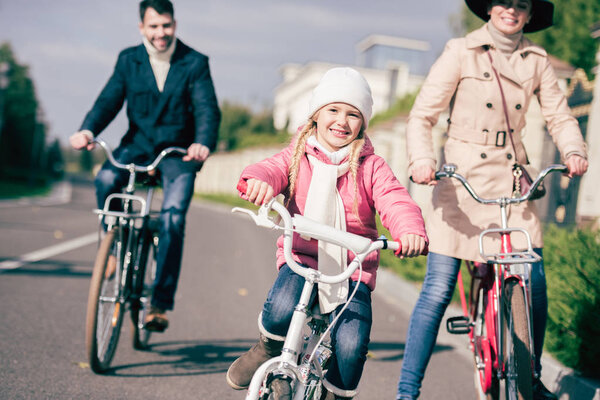 开朗的家庭在公园里骑自行车  图片素材
