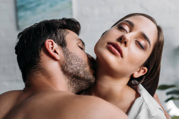男朋友亲吻感性女朋友脖子在卧室在早晨 图片素材