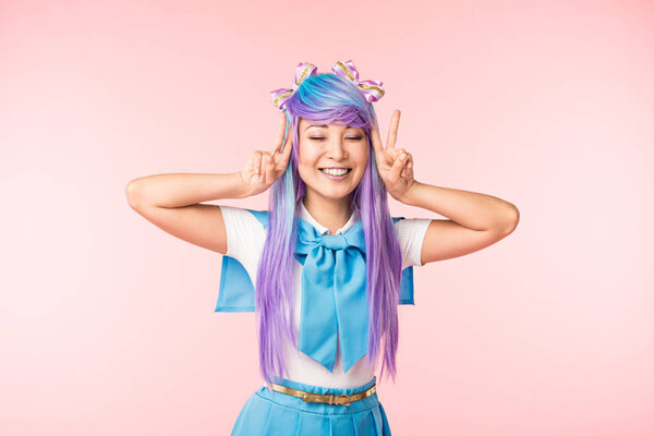 快乐动漫女孩在紫色假发显示和平的迹象与粉红色的闭眼 图片素材