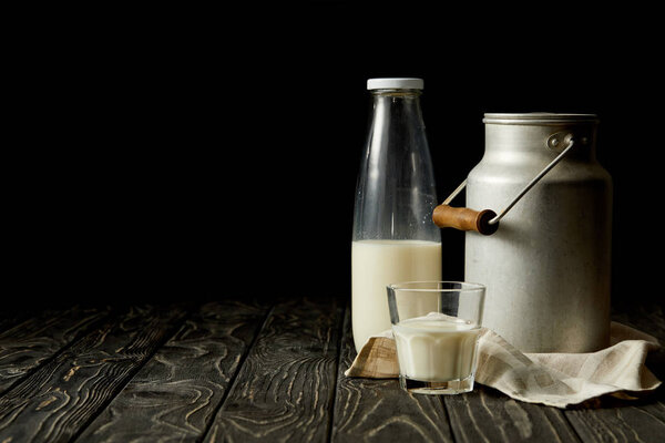牛奶在瓶, 玻璃和铝罐头在麻布在黑背景  图片素材