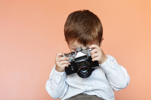带着旧复古相机的小男孩。年轻的摄影师。带旧照相机的孩子 图片素材