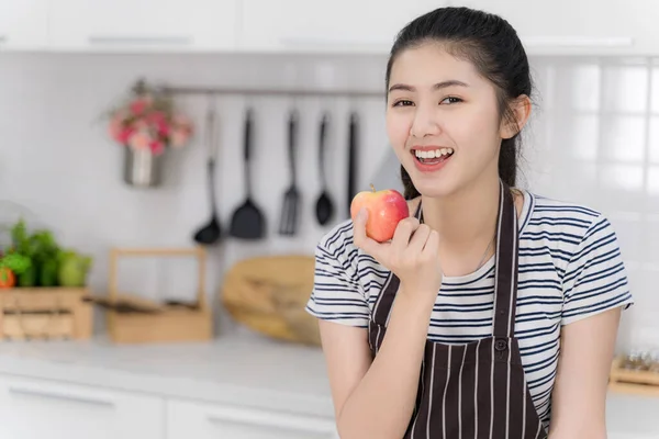 亚洲美女的画像是微笑,手里拿着红苹果.健康食品概念