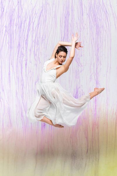 有吸引力的芭蕾舞女郎在白色礼服穿在灰色背景与五颜六色的溢出  图片素材