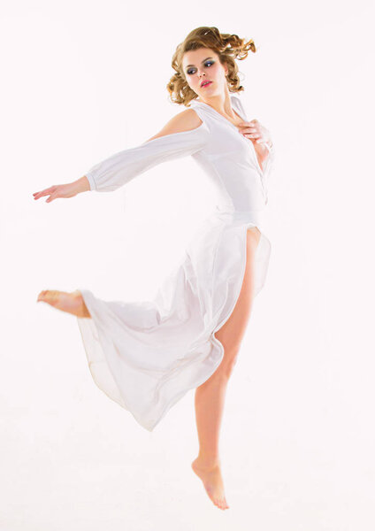 感觉新鲜和失重。女孩有吸引力的复古模型在白色背景。女人优雅的女士复古发型化妆飞或跳在白色礼服。性感的复古时尚礼服。神圣之美 图片素材