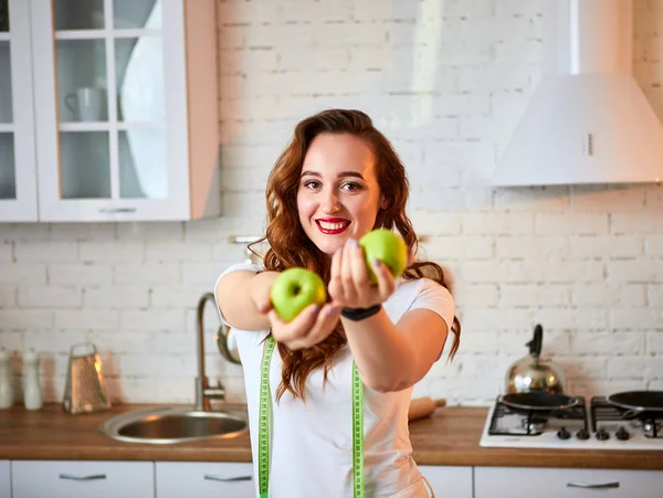 年轻的快乐女人与现代厨房的绿色苹果。健康食品和饮食理念。减重 图片素材